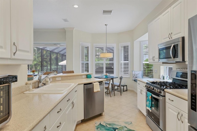 kitchen with white cabinets, plenty of natural light, stainless steel appliances, and hanging light fixtures