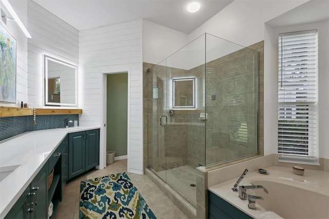 full bathroom with tile patterned floors, plenty of natural light, separate shower and tub, and vanity