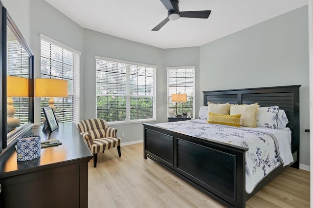 bedroom featuring ceiling fan, light wood-type flooring, and multiple windows