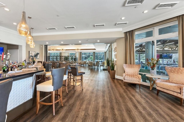 bar featuring pendant lighting, dark hardwood / wood-style flooring, and ornamental molding