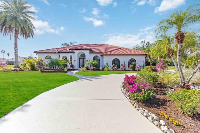 mediterranean / spanish-style home with a front lawn