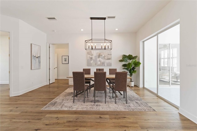 dining room with hardwood / wood-style flooring and an inviting chandelier