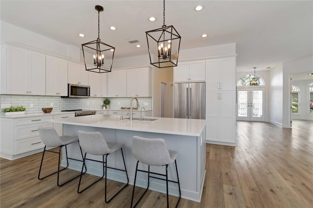 kitchen with a large island, white cabinets, and stainless steel appliances