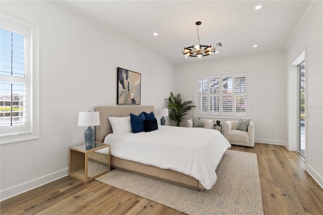 bedroom featuring light wood-type flooring, an inviting chandelier, and crown molding