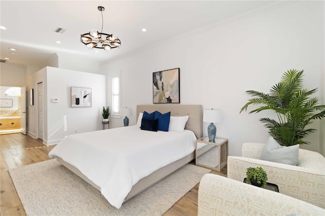 bedroom featuring crown molding, light hardwood / wood-style flooring, and an inviting chandelier