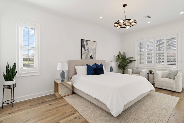 bedroom with a notable chandelier, light hardwood / wood-style floors, and crown molding