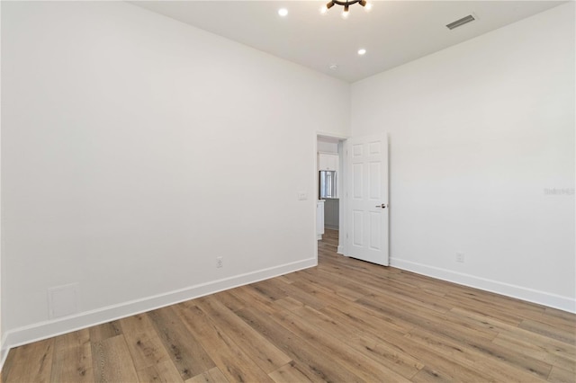 unfurnished room featuring a high ceiling and light hardwood / wood-style flooring