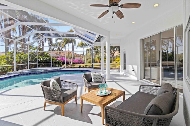 view of pool with glass enclosure, ceiling fan, an in ground hot tub, and a patio