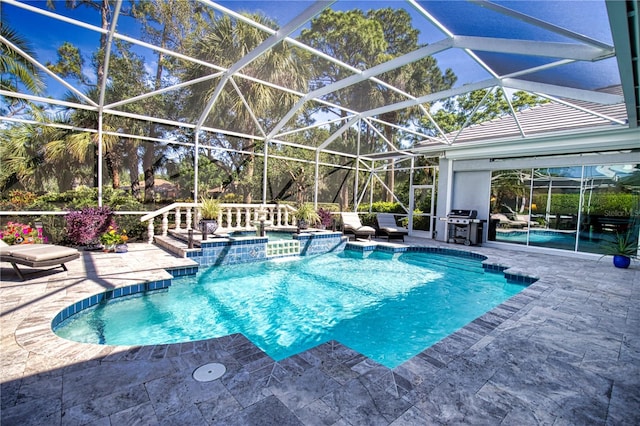 view of swimming pool featuring an in ground hot tub, a patio, glass enclosure, and grilling area