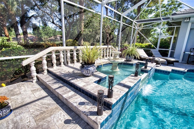 view of pool featuring a lanai, pool water feature, a patio, and an in ground hot tub