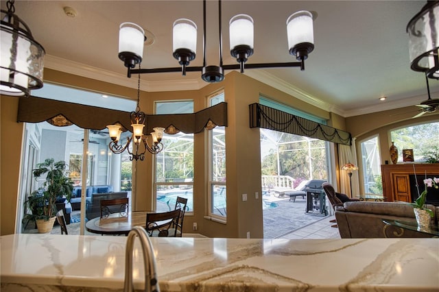 interior space with crown molding, a healthy amount of sunlight, and ceiling fan with notable chandelier