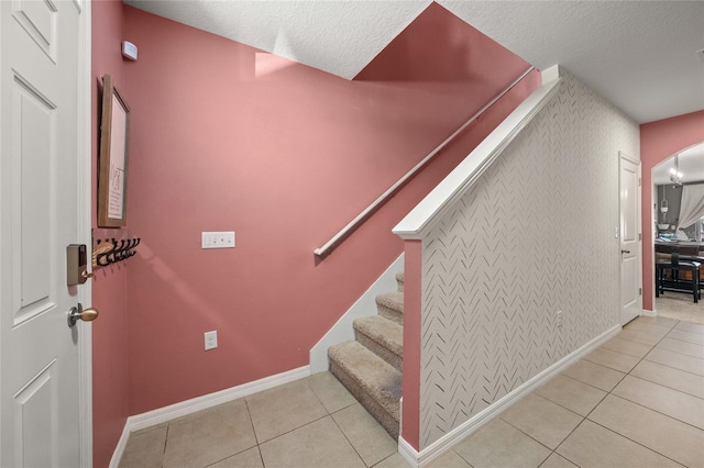 stairs with tile patterned flooring and a textured ceiling