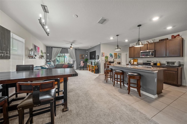 tiled dining area featuring ceiling fan and a textured ceiling