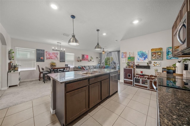 kitchen featuring sink, an island with sink, hanging light fixtures, and appliances with stainless steel finishes