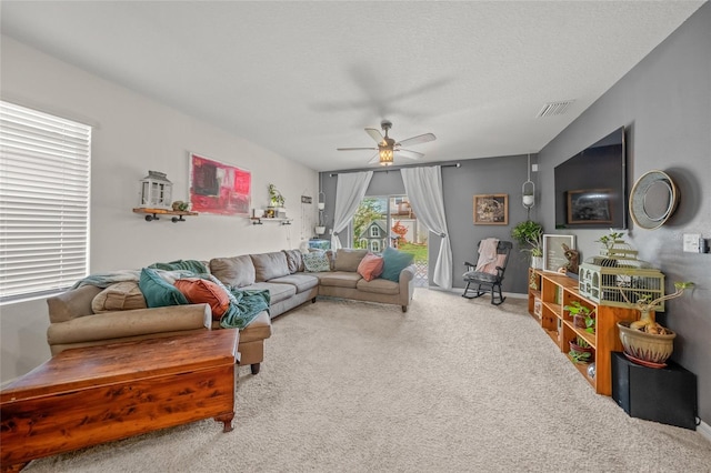 living room featuring carpet, a textured ceiling, and ceiling fan