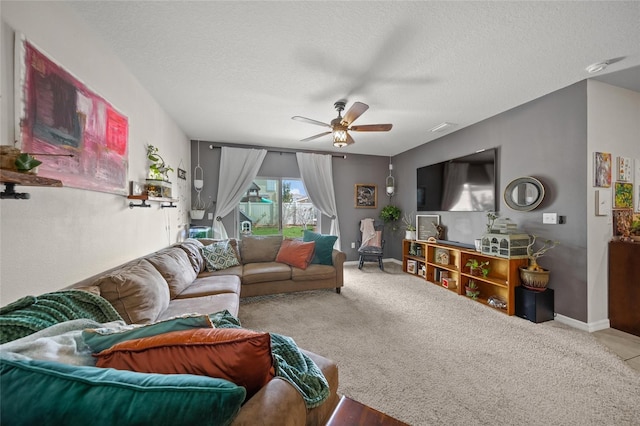 living room with carpet flooring, ceiling fan, and a textured ceiling