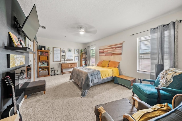 carpeted bedroom with ceiling fan, a textured ceiling, and multiple windows