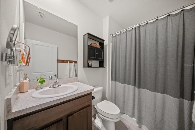 bathroom featuring tile patterned flooring, vanity, toilet, and curtained shower