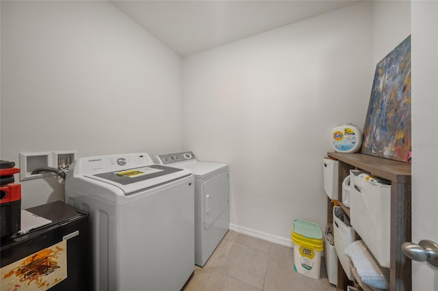 laundry area featuring washing machine and dryer and light tile patterned floors