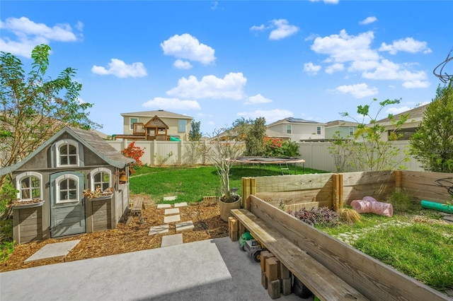 view of yard featuring an outbuilding and a trampoline