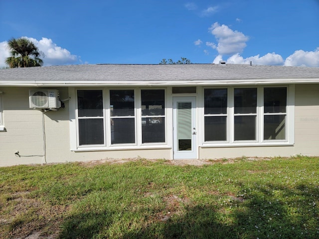 back of property featuring ac unit and a yard