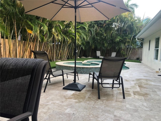 view of patio / terrace with an in ground hot tub