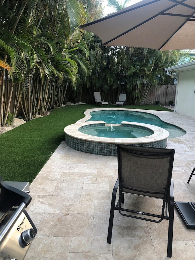 view of swimming pool with an in ground hot tub and a patio