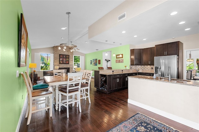 kitchen with dark brown cabinetry, sink, a center island, lofted ceiling with beams, and stainless steel fridge