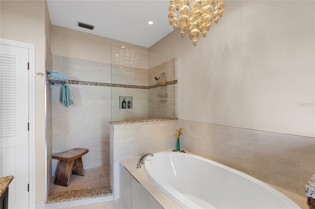 bathroom with a notable chandelier and independent shower and bath