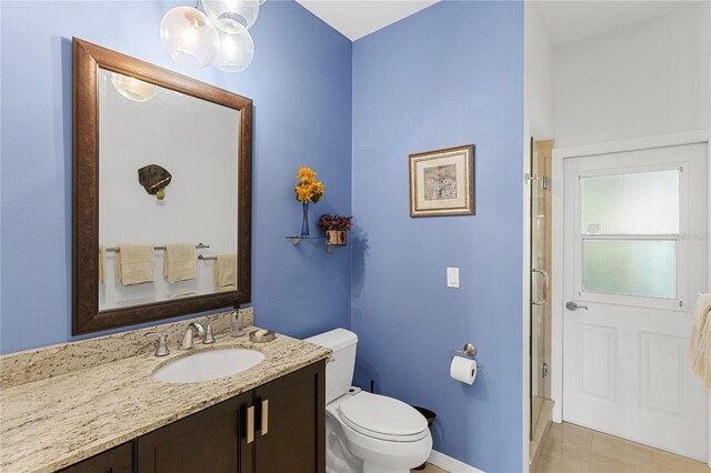 bathroom with tile patterned floors, vanity, toilet, and a shower with shower door