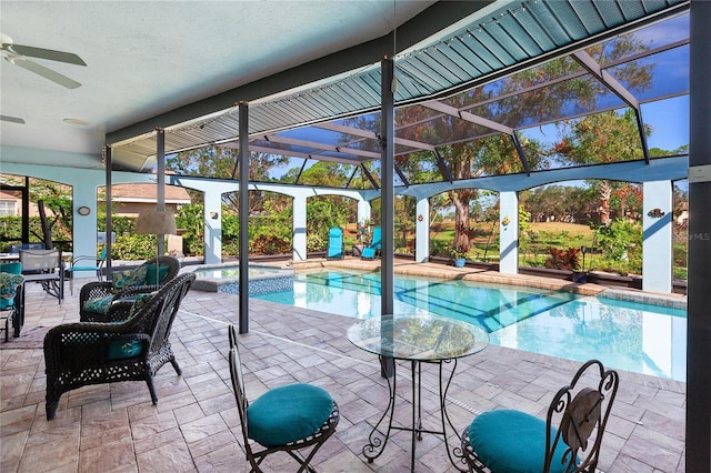 view of swimming pool with ceiling fan, a patio area, a lanai, and an in ground hot tub