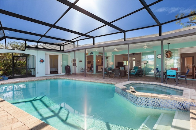 view of swimming pool featuring an in ground hot tub, glass enclosure, ceiling fan, and a patio area