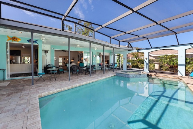 view of pool with a patio, ceiling fan, an in ground hot tub, and glass enclosure