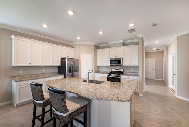 kitchen featuring sink, stainless steel appliances, an island with sink, and white cabinets