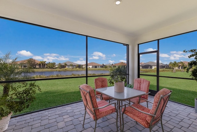 sunroom / solarium featuring a water view