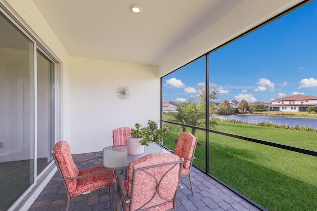 sunroom featuring a water view