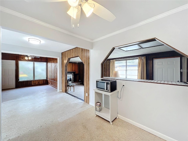 2877 Michigan St, Sarasota, FL 34237 - kitchen featuring stainless steel microwave, a ceiling fan, baseboards, arched walkways, and wood walls