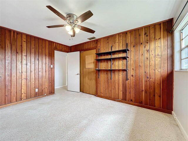 2877 Michigan St, Sarasota, FL 34237 - unfurnished bedroom featuring baseboards, wood walls, and a ceiling fan