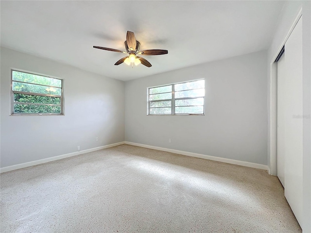 2877 Michigan St, Sarasota, FL 34237 - unfurnished bedroom featuring a closet, baseboards, a ceiling fan, and dark speckled floor