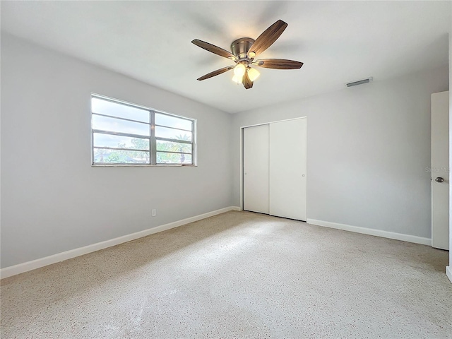 unfurnished bedroom with ceiling fan and a closet