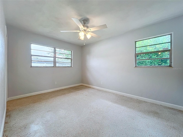 unfurnished room featuring ceiling fan and plenty of natural light