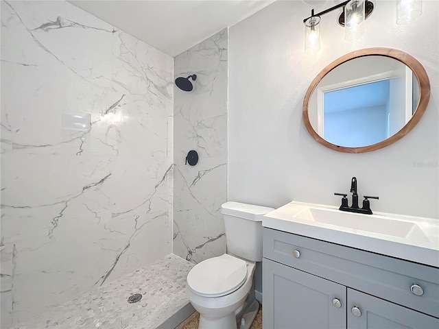 bathroom featuring vanity, toilet, and a tile shower