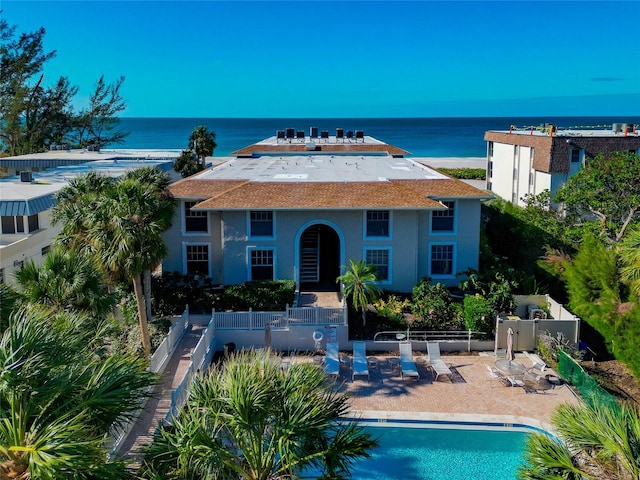 view of swimming pool featuring a water view and a patio