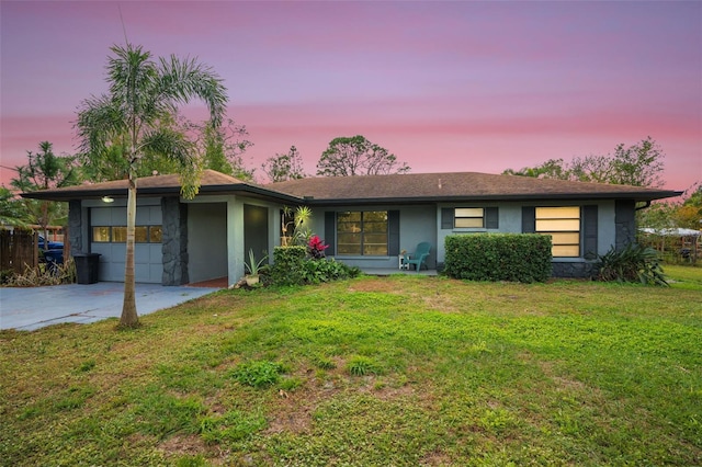 ranch-style house featuring a garage and a lawn