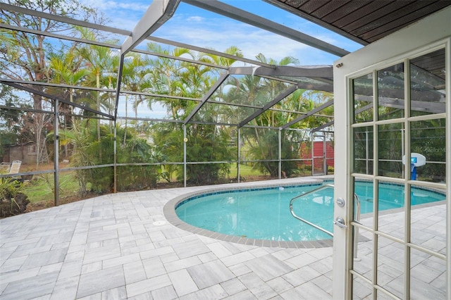 view of swimming pool featuring a patio and glass enclosure