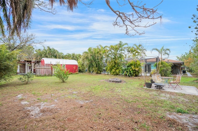 view of yard with a patio, an outdoor structure, and a fire pit