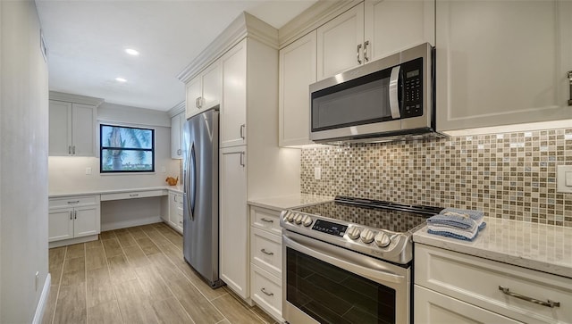 5760 Midnight Pass Rd Unit 307D, Sarasota, FL 34242 - kitchen with stainless steel appliances, backsplash, white cabinetry, built in study area, and recessed lighting