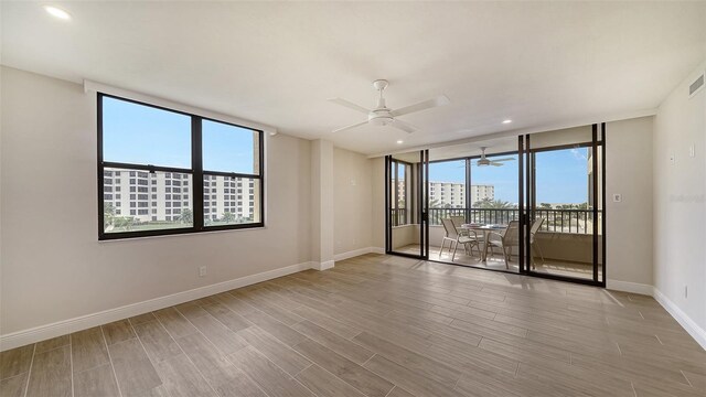 spare room featuring light hardwood / wood-style flooring, plenty of natural light, and ceiling fan