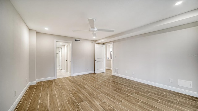 empty room with ceiling fan and light hardwood / wood-style flooring