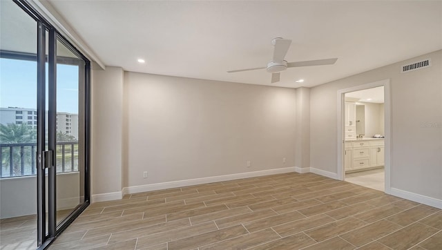 empty room with a wealth of natural light, light hardwood / wood-style flooring, and ceiling fan